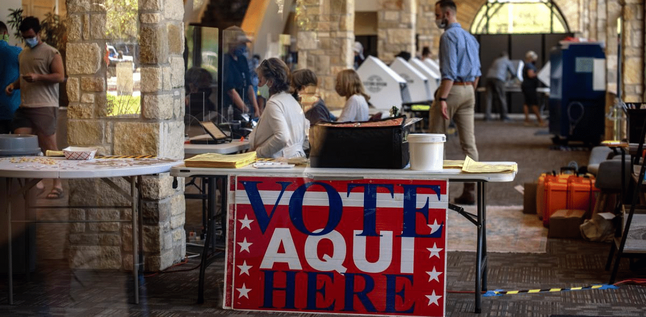 Poll workers help voters inside a polling location in Austin, Texas. Credit: AFP Photo