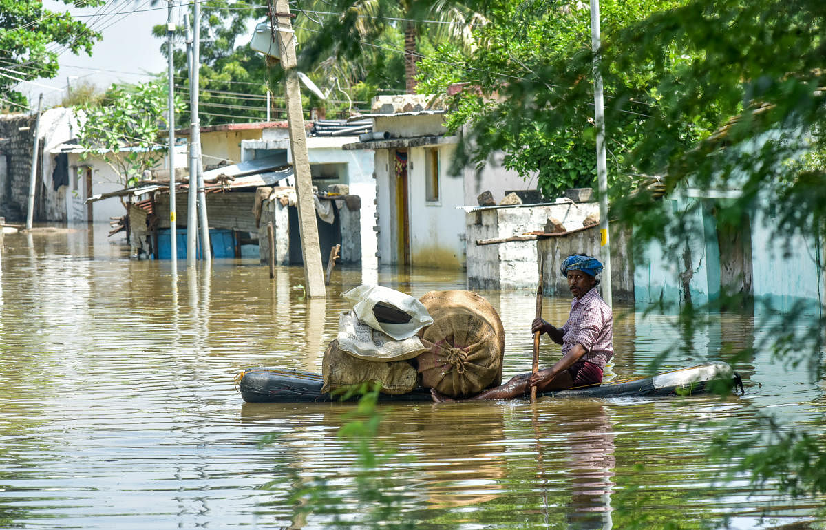 A man shifts household articles on a makeshift boat in the marooned Haravala village of Jewargi taluk in Kalaburagi district on Monday. DH Photo/Prashanth H G