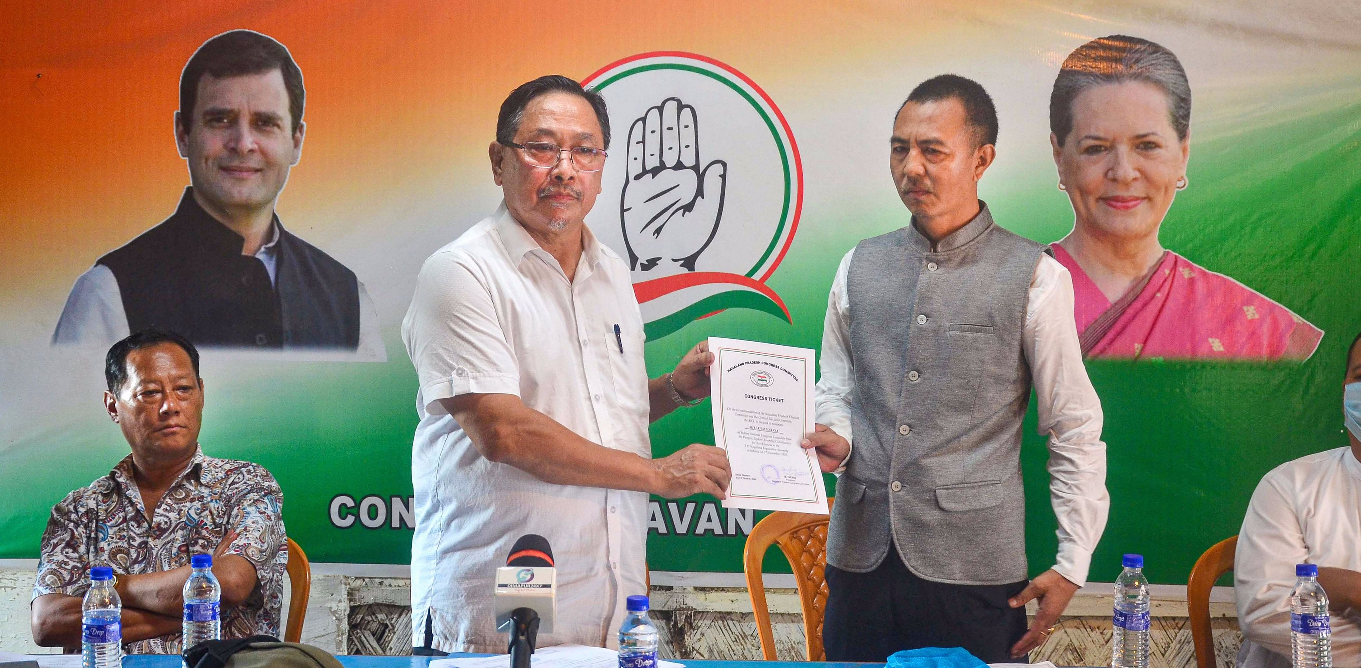 President of Nagaland Pradesh Congress Committee K Therie (L) presents party ticket to Khaseo Anar (R), ahead of the upcoming Nagaland bypolls, at Congress Bhavan in Dimapur. Credit: PTI