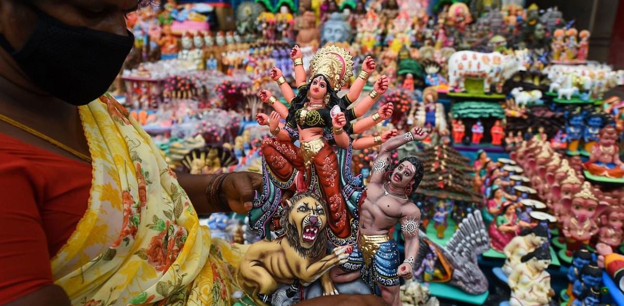  A shopkeeper holds an idol representing deities and characters from the Hindu mythology, ahead of the Navaratri festival, in Chennai. Credit: PTI