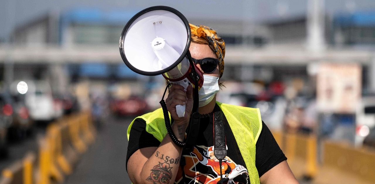 A woman uses a megaphone during a protest of migrants and human rights activists against US and Mexican migration policies at the San Ysidro crossing port, in Tijuana, Baja California state, Mexico. Credit: AFP Photo