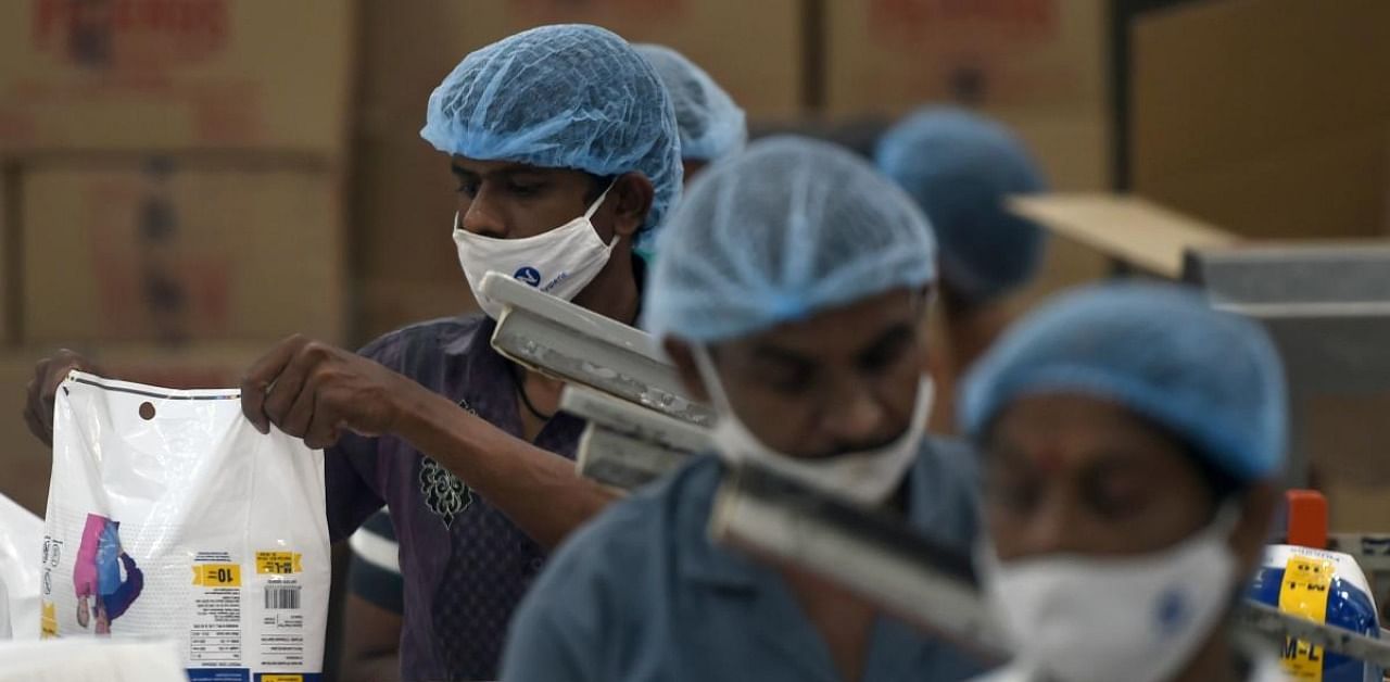 In this picture taken on October 1, 2020, staff members work on the production line of a diaper manufacturing plant in Sinnar, in the Indian state of Maharashtra. Credit: AFP Photo