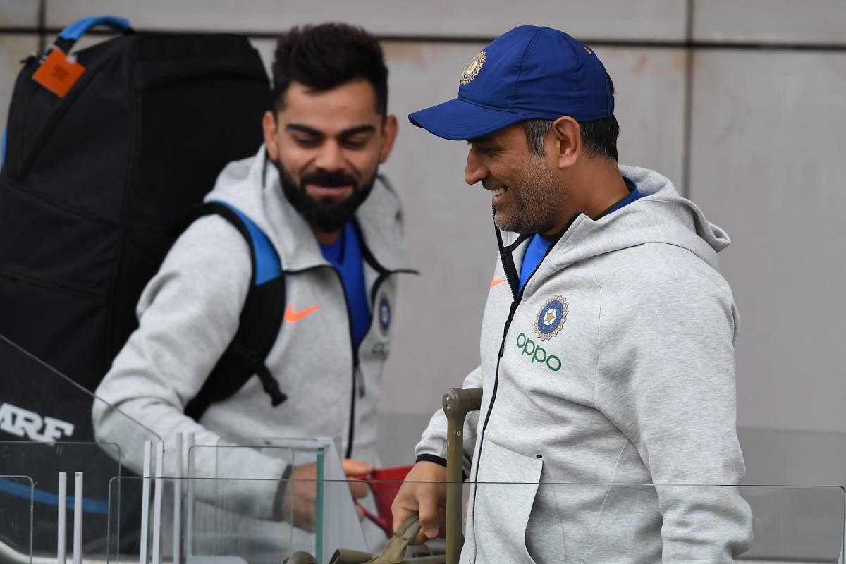 India's M S Dhoni (right) and captain Virat Kohli look relaxed as they arrive for a training session at Old Trafford on Saturday. AFP