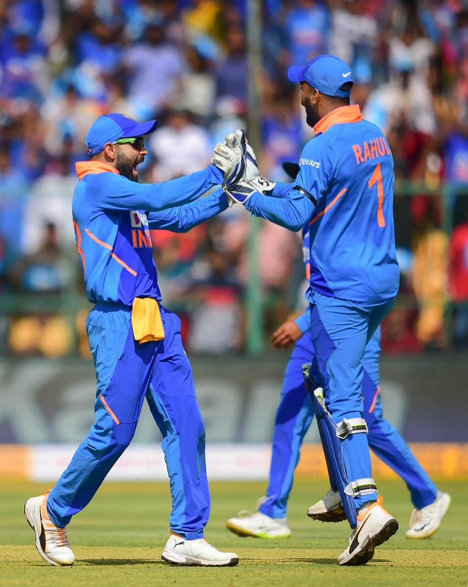 Indian skipper Virat Kohli (L) with teammate K L Rahul (R) celebrates the dismissal of Australia's batsman Aaron Finch during the third and final ODI cricket match, at Chinnaswamy Stadium in Bengaluru (PTI Photo)