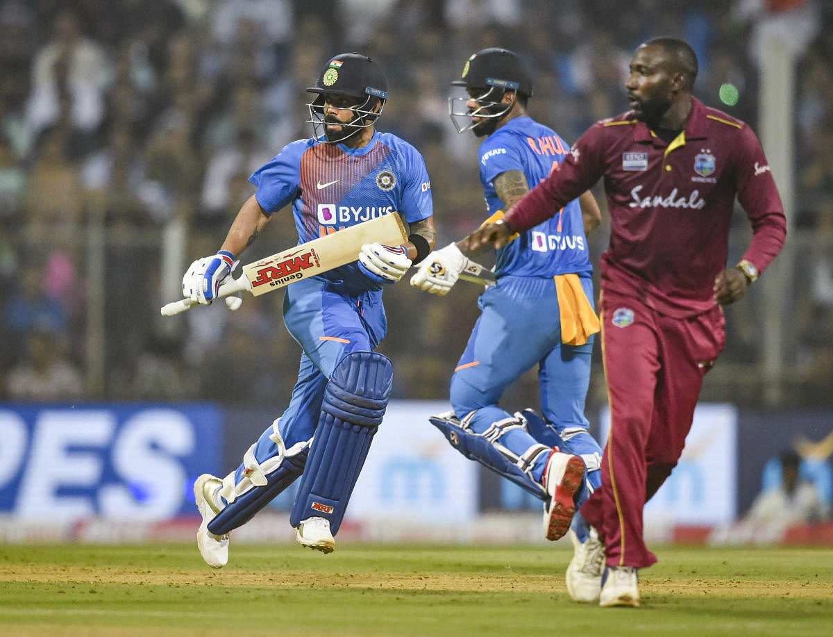 ndian players Virat Kohli and KL Rahul run between the wickets during the third T20 cricket match against West Indies (PTI Photo)