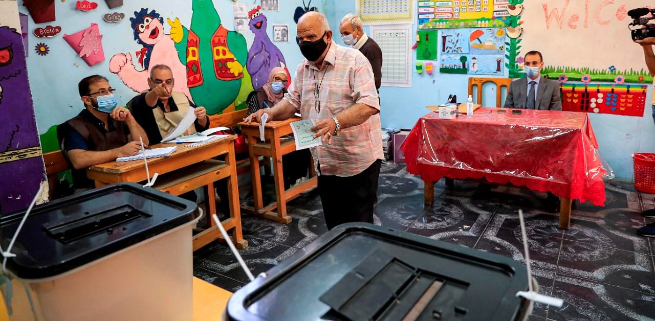A man prepares to cast his vote at a polling station in the Agouza district in Giza while voting in the first stage of the lower house elections. Credit: AFP Photo