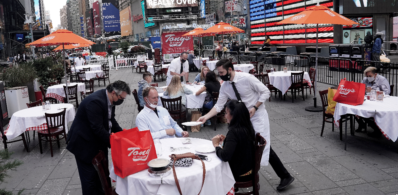 Servers deliver food to a table at a pop up restaurant set up in Times Square in New York. Credits: Reuters Photo