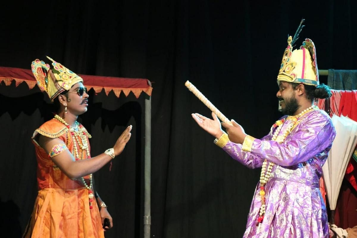 Music assistant R C Dhananjaya and light designer Mahesh Kalletti of Rangayana repertory enact a scene from the play ‘Door No 8’, in Mysuru.