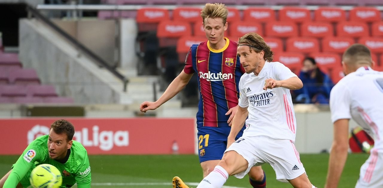 Real Madrid's Croatian midfielder Luka Modric (R) scores a goal during the Spanish League football match between Barcelona and Real Madrid at the Camp Nou stadium in Barcelona. Credit: AFP Photo