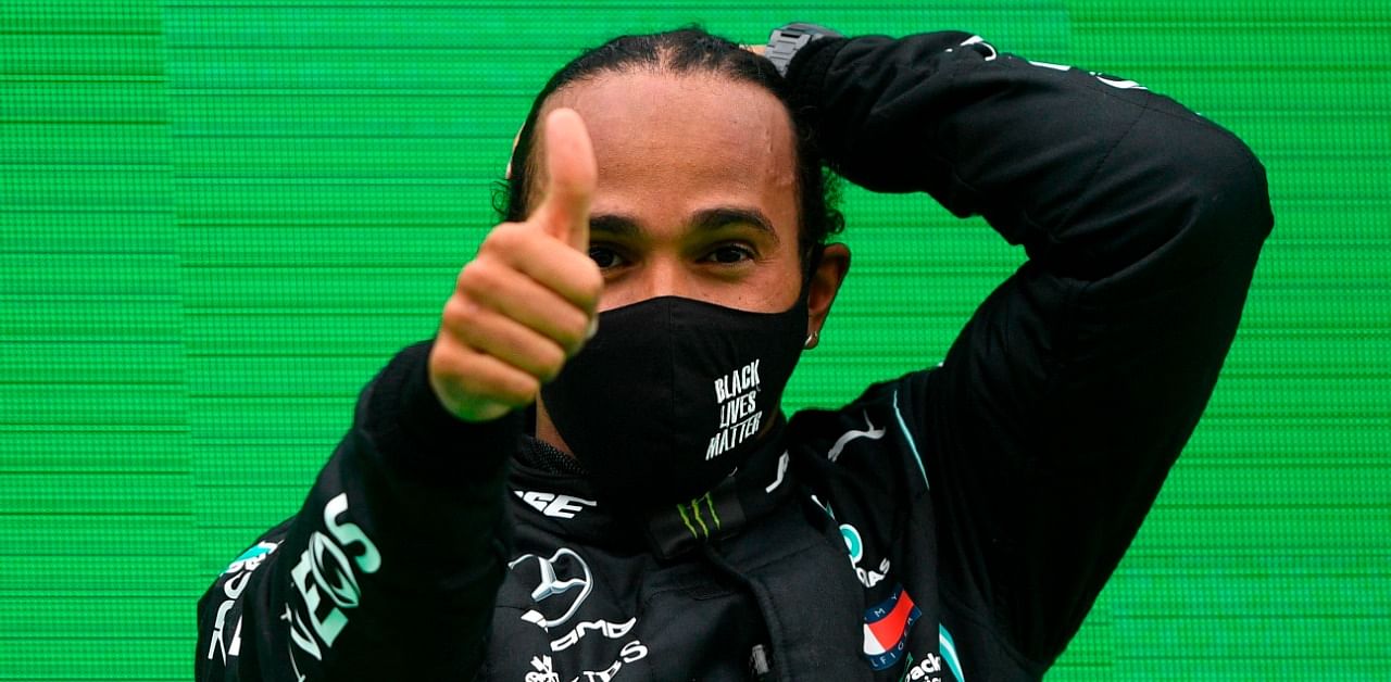 Mercedes' British driver Lewis Hamilton celebrates on the podium after winning the Portuguese Formula One Grand Prix. Credit: AFP