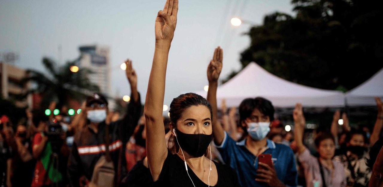 Pro-democracy protesters hold up the three-finger salute outside Bangkok Remand Prison in Bangkok as they urged the release of protest leaders and other activists held at the facility following arrests during the ongoing demonstrations. Credit: AFP Photo