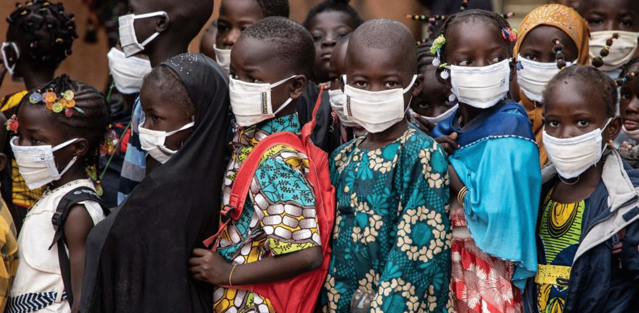 Pupils wearing face masks wait for the opening of their primary school on the first day of the new school year, in Ouagadougou, on October 1, 2020.  Credit: AFP Photo