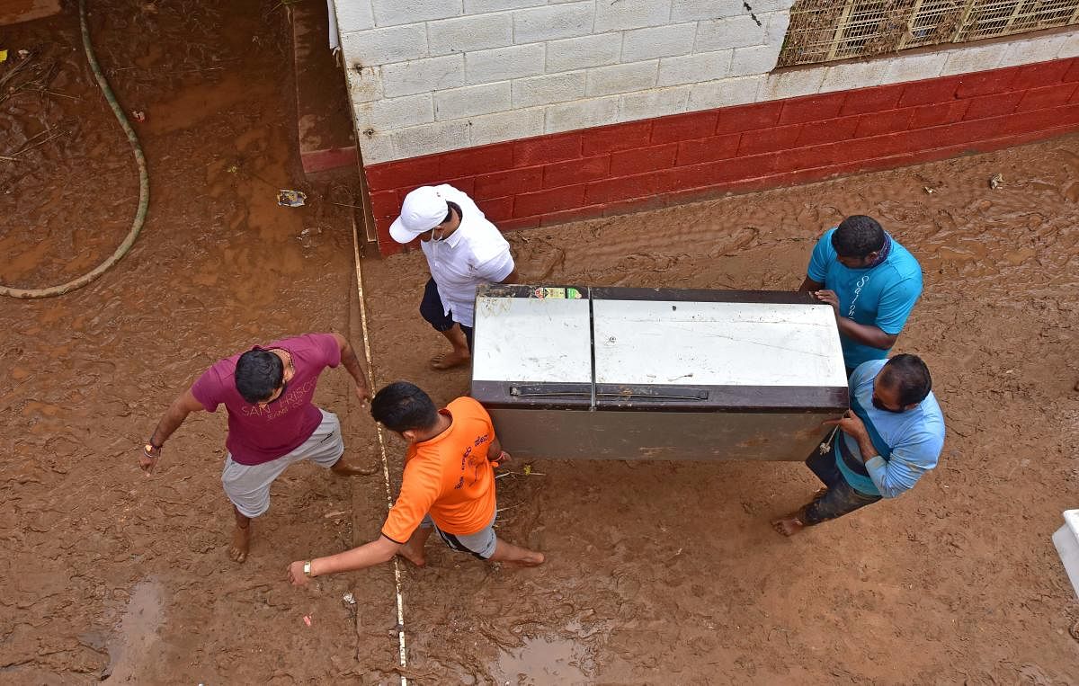 Residents shift a refrigerator out of a waterlogged home in Hosakerehalli, Bengaluru, on Saturday. DH PHOTO/IRSHAD MAHAMMAD