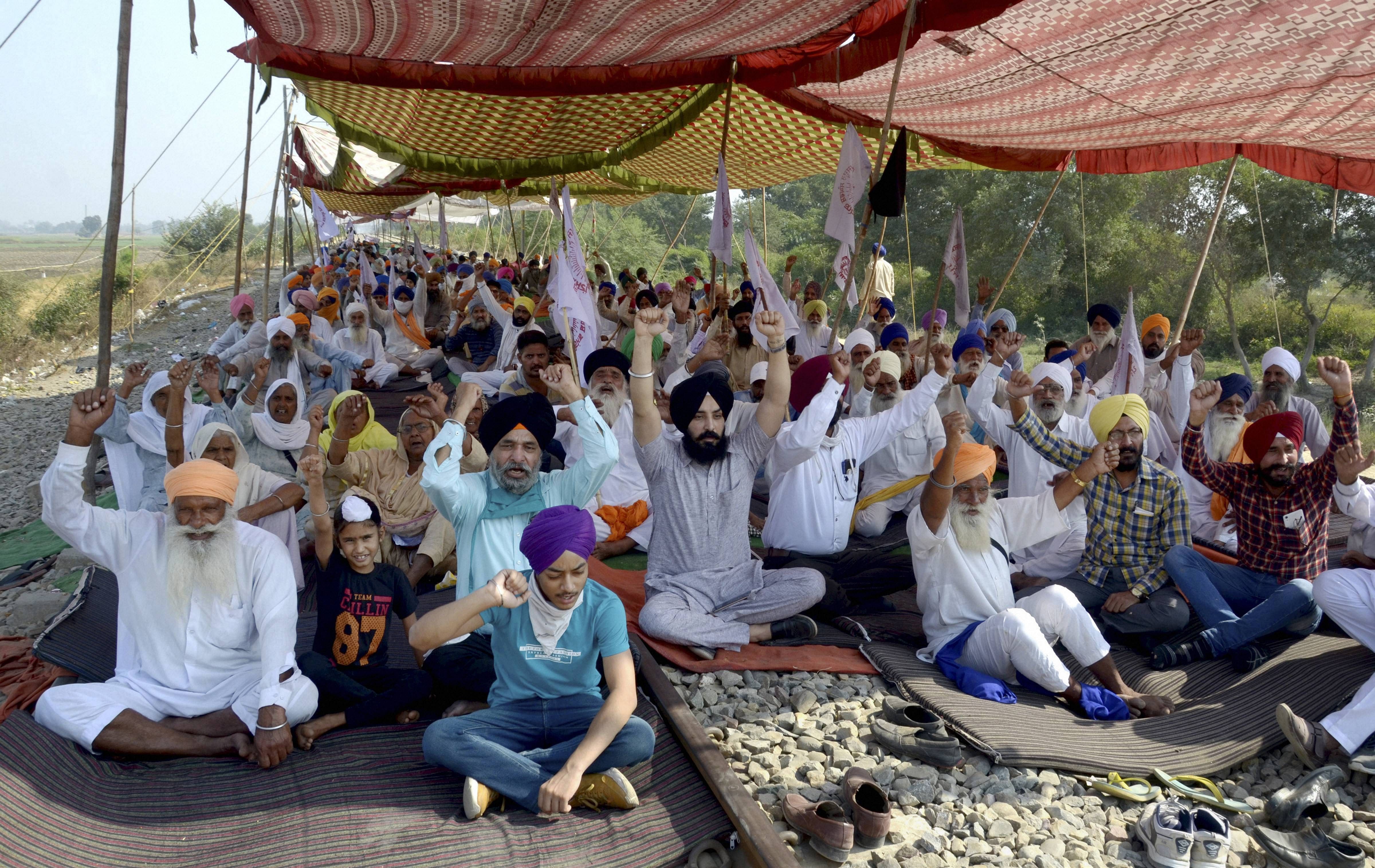 Farmers shout slogans during their ongoing 'Rail Roko' protest over new farm laws. Credits: PTI Photo