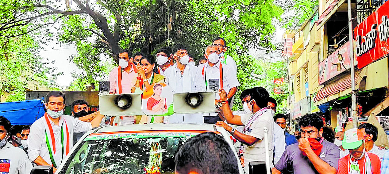 KPCC president D K Shivakumar and Kusuma H, the party candidate for the bypoll-bound Rajarajeshwarinagar Assembly segment, take out a road show at Gorguntepalya on Saturday. Credit: DH Photo