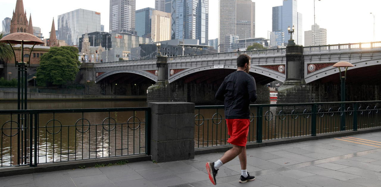  A solitary man runs along a waterway under Covid-19 lockdown restrictions in Melbourne. Credit: AFP Photo