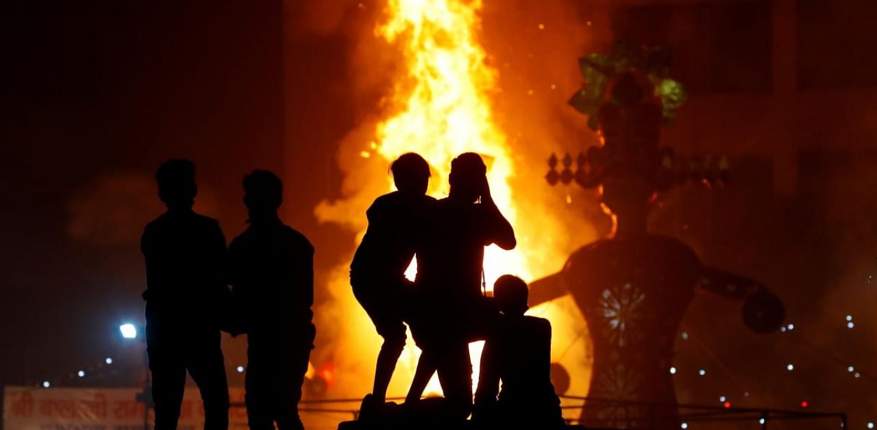 People watch as an effigy of Kumbhkarana, brother of demon king Ravana, burns during Dussehra festival celebrations, amid the outbreak of the coronavirus disease. Credit: Reuters.