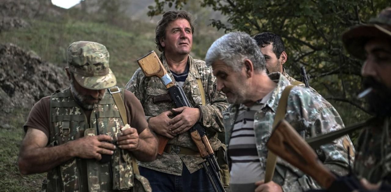 In this file photo volunteer fighters stand in a valley outside a village south-east of Stepanakert on October 23, 2020, during the ongoing fighting between Armenian and Azerbaijani forces over the breakaway region of Nagorno-Karabakh. Credit: AFP.