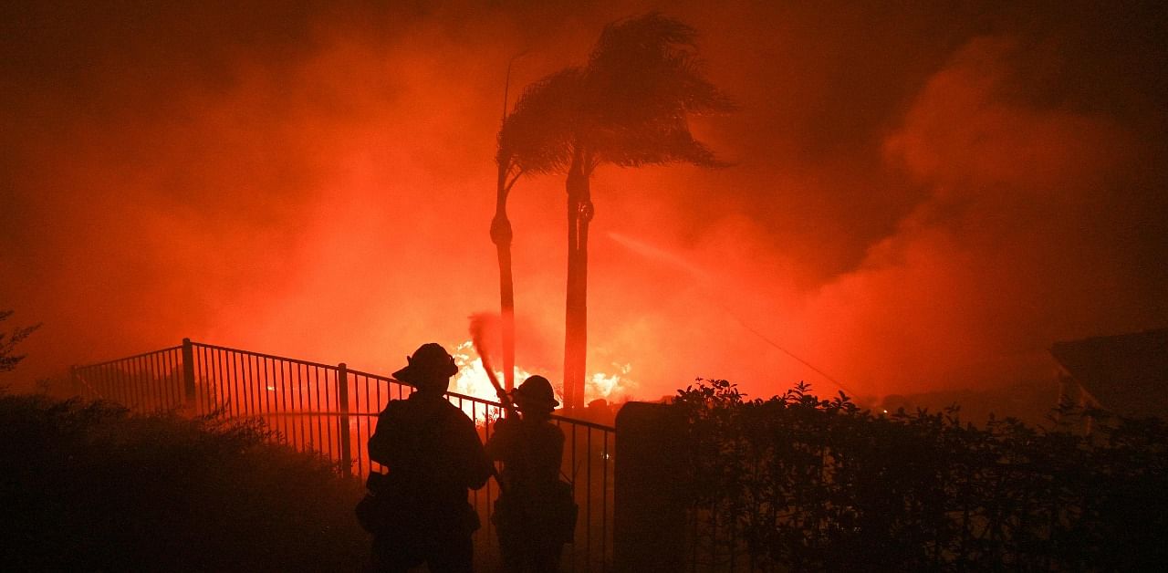 Firefighters try to surpress flames from a home patio at the Blue Ridge Fire in Yorba Linda, California. Credit: AFP