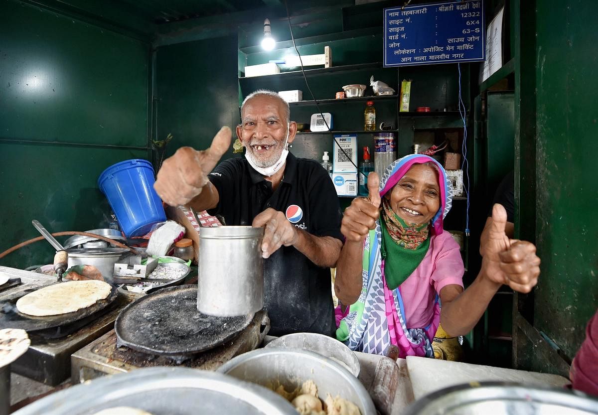 80-year-old Kanta Prasad and Badami Devi, couple and co-owners of 'Baba Ka Dhaba', pose for photographs at their eatery. Credit: PTI