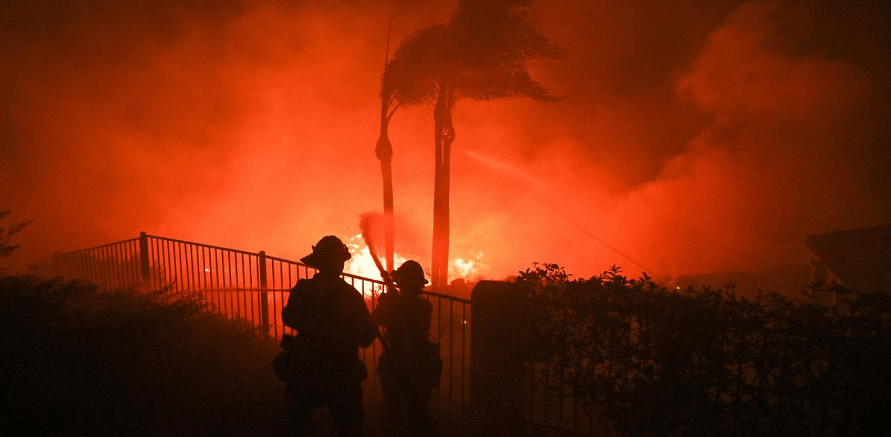 Firefighters try to surpress flames from a home patio at the Blue Ridge Fire in Yorba Linda, California, US. Credit: AFP Photo