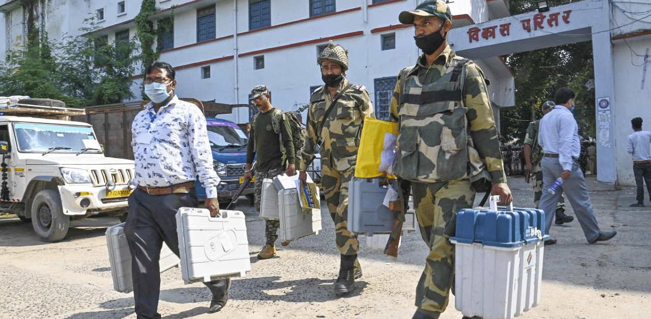 Security personnel carrying Electronic Voting Machines (EVMs) on their way to a polling booth on the eve of first phase of Bihar Assembly Elections, in Gaya district. Credit: PTI Photo