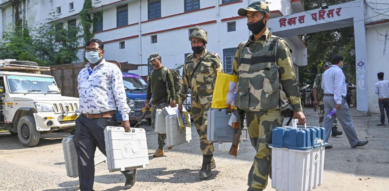 Security personnel carrying Electronic Voting Machines (EVMs) on their way to a polling booth on the eve of first phase of Bihar Assembly Elections, in Gaya. Credit: PTI.