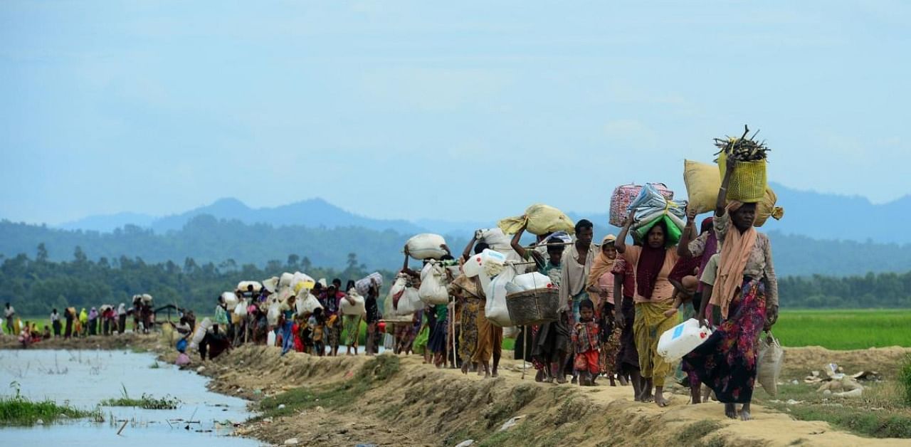 In this file photo taken on October 19, 2017 Rohingya refugees who were stranded walk near the no man's land area between Bangladesh and Myanmar in the Palongkhali area next to Ukhia. Credit: AFP Photo