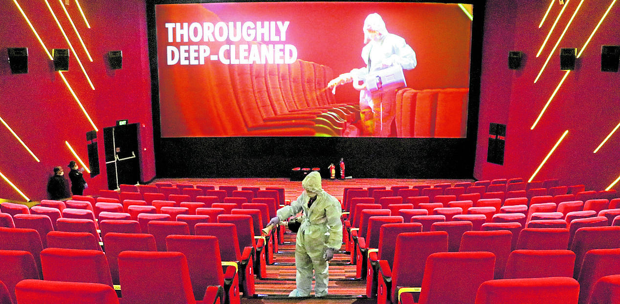 A worker wearing personal protective equipment (PPE) sanitizes seats inside the Inox Leisure movie theatre ahead of its reopening, amidst the outbreak of the coronavirus disease (COVID-19), in Mumbai. Credit: Reuters