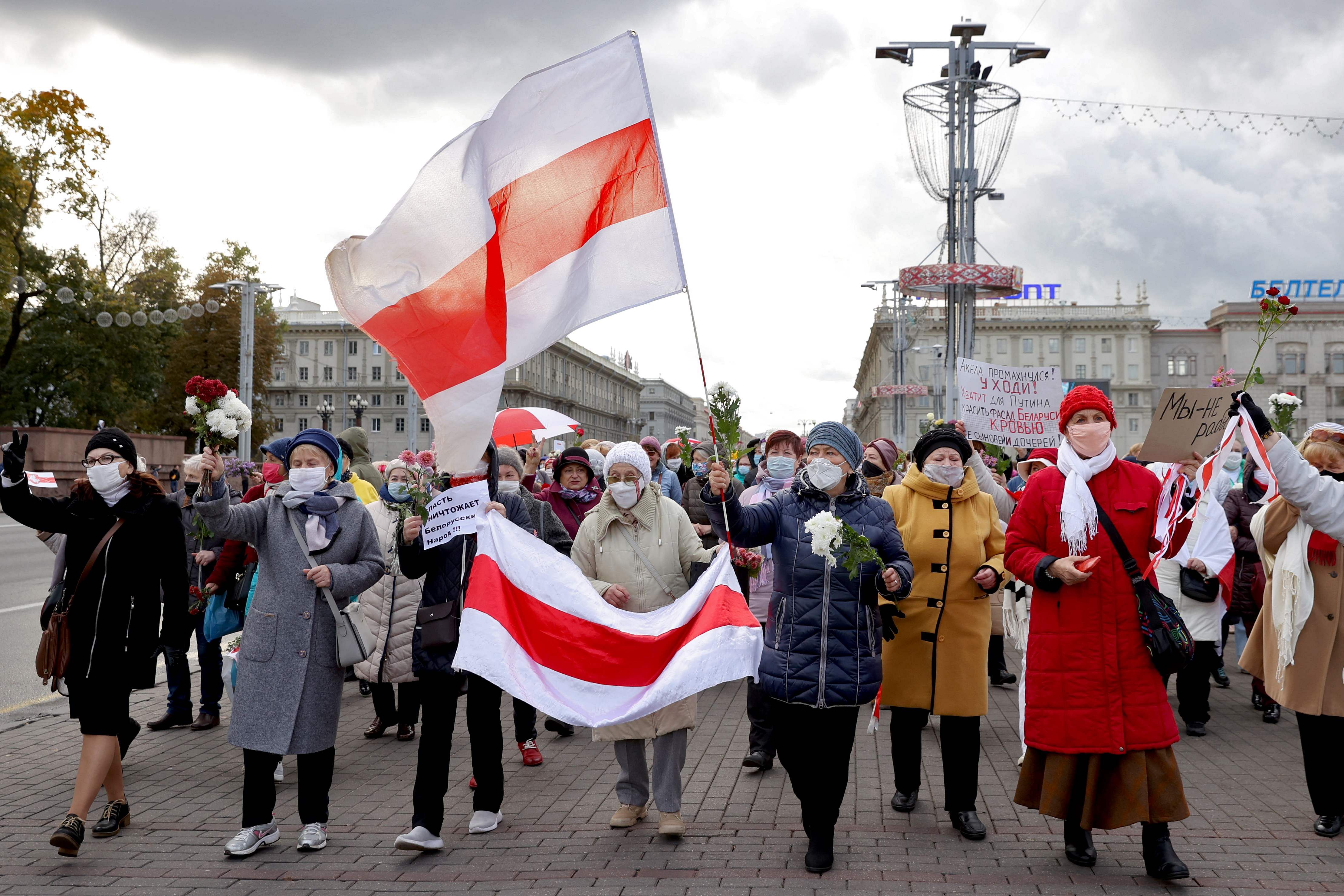 Belarusian pensioners carrying former white-red-white flags of Belarus and flowers parade through the streets during a rally to demand the resignation of authoritarian leader and new fair election. Credits: AFP Photo