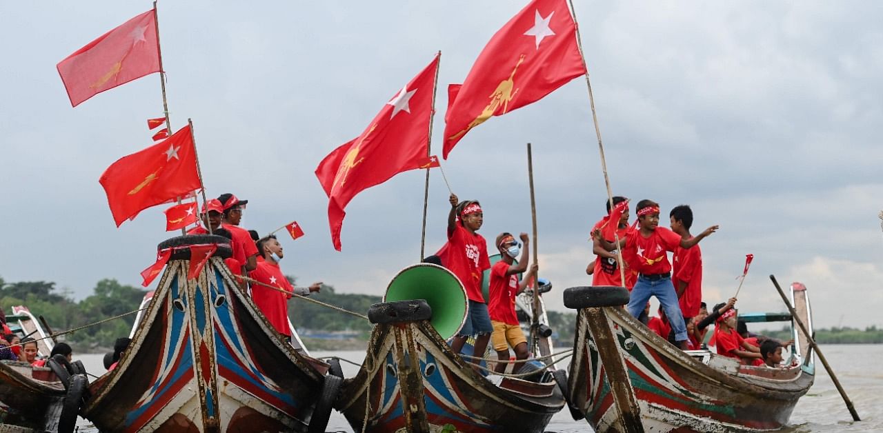 Supporters of the National League for Democracy (NLD) party ride on wooden boats in Yangon river, during an election campaign rally on the outskirts of Yangon. Credit: AFP Photo