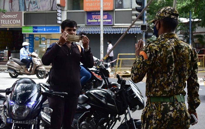 A marshal stops a motorcyclist over face mask in Jayanagar, Bengaluru. DH PHOTO/IRSHAD MAHAMMAD