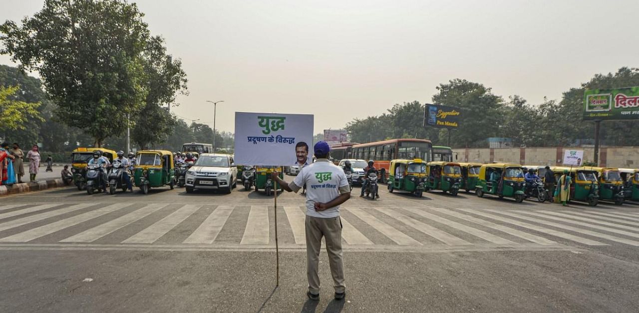 A Civil Defence volunteer holds a placard during 'Red Light On, Gaadi Off' campaign, launched by Delhi Government to tackle air pollution, in New Delhi. Credit: PTI