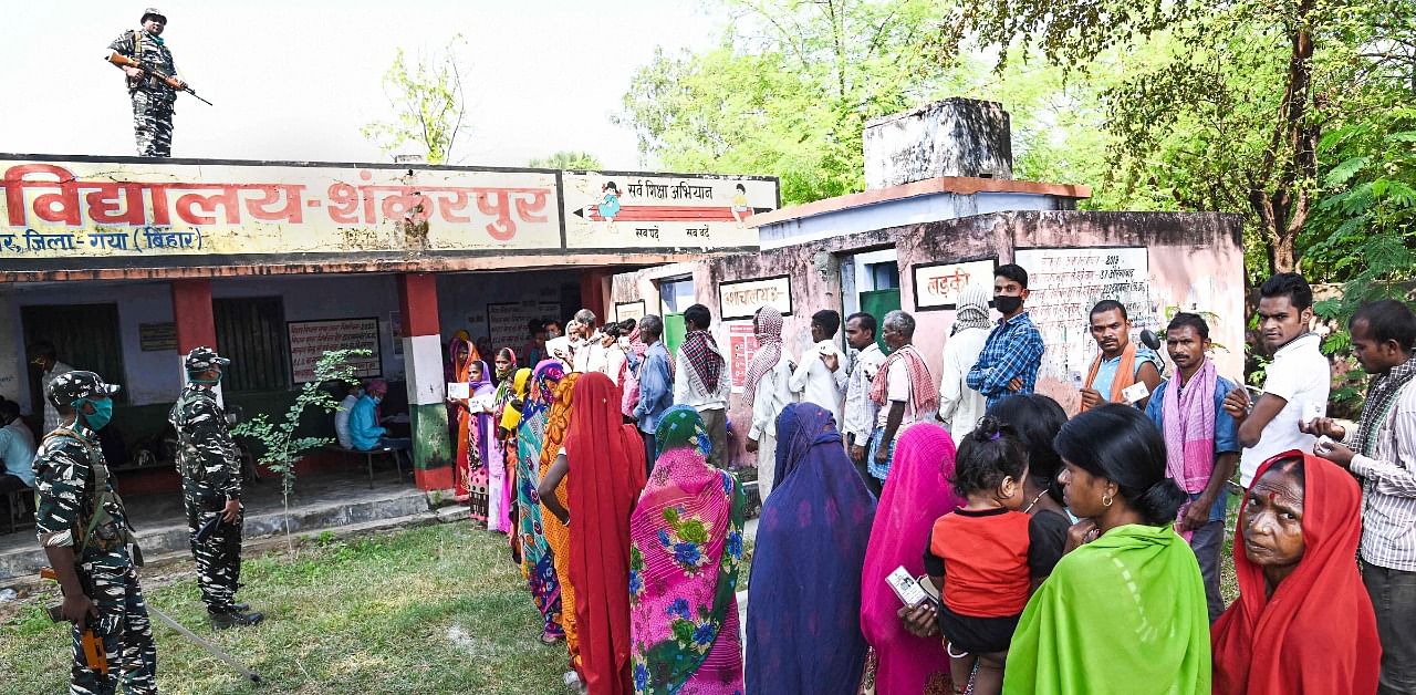 Voters stand in queues to cast their votes for the first phase of Bihar Assembly Elections, at Bankey Bazar in Gaya district. Credit: PTI Photo