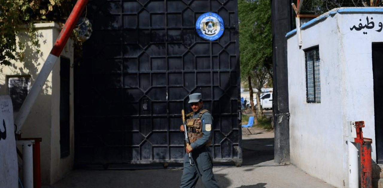 An Afghan policeman stands guard at an entrance gate of a prison in Herat on October 29, 2020. Credit: AFP Photo