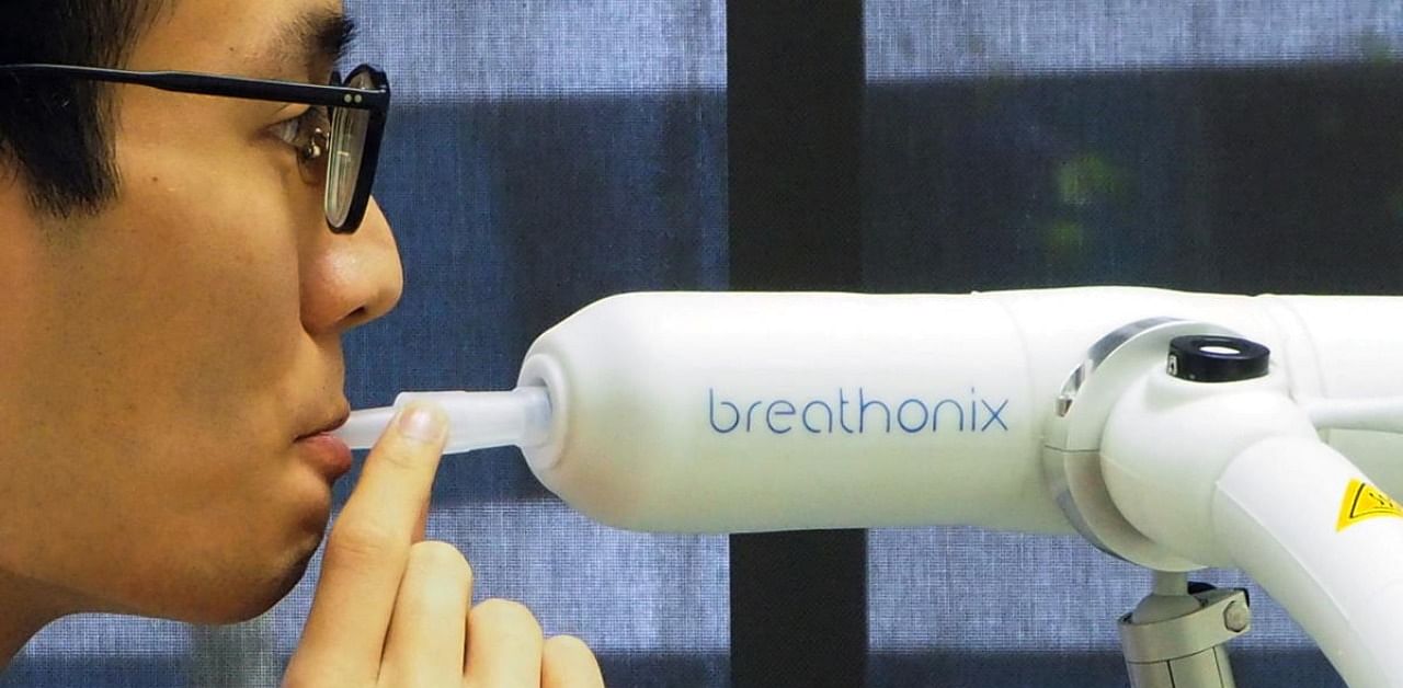 A staff member demonstrates the usage of Breathonix breathalyzer test kit developed by Breathonix, a start-up by the National University of Singapore, able to detect the coronavirus disease within a minute according to the company. Credit: Reuters