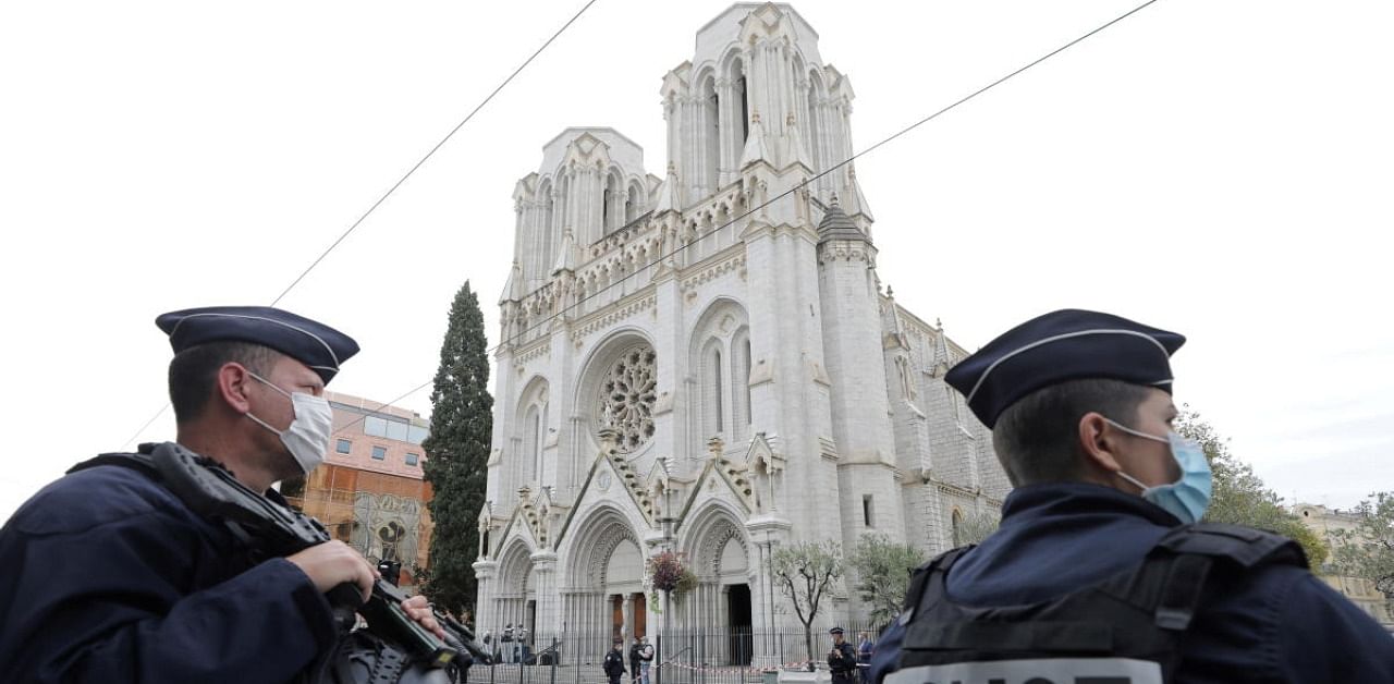 Police officers stand guard at the scene of a reported knife attack at Notre Dame church in Nice, France. Credit: Reuters