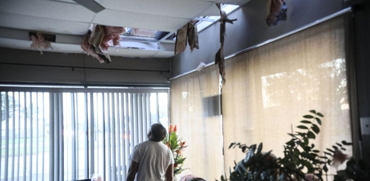 Tom Nguyn surveys the damage to his nail salon after Hurricane Zeta in Chalmette, Louisiana. Credit: AFP