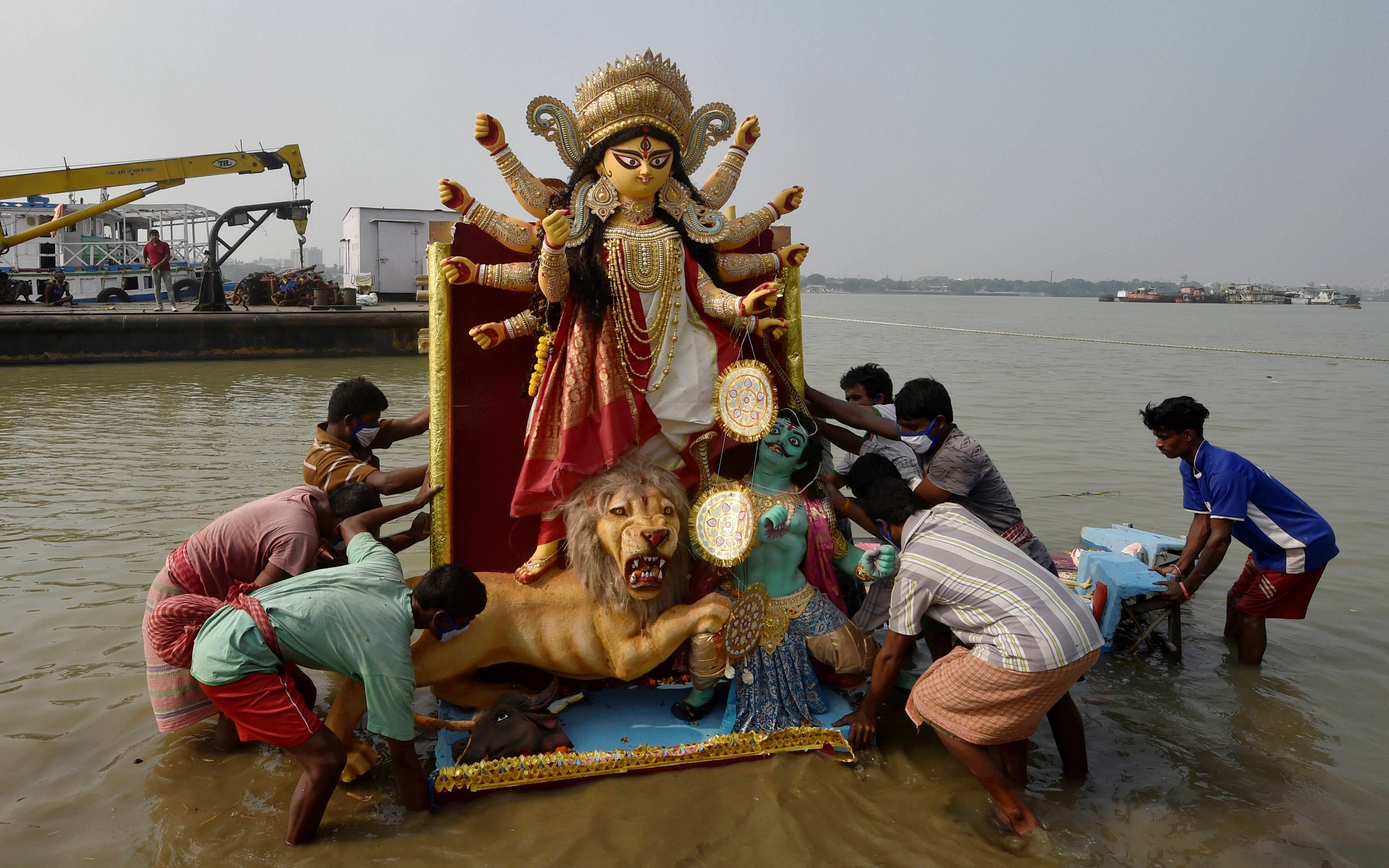 Devotees immerse an idol of Goddess Durga in Ganga river after Durga Puja festival, in Kolkata, Wednesday, Oct. 28, 2020. Credit: PTI Photo
