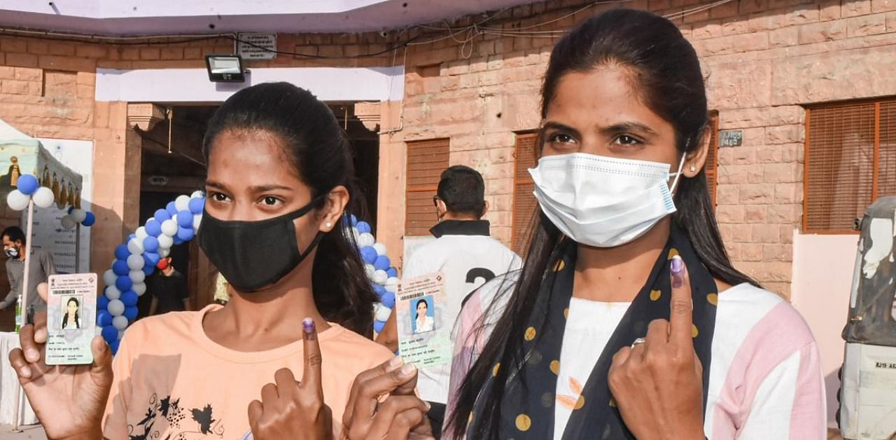 Voters show their finger marked with indelible ink after casting vote during the municipal corporation elections in Jodhpur. Credit: PTI.