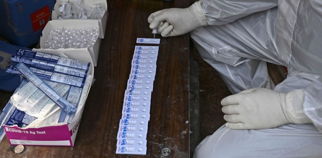 A health worker checks nasal swab samples collected from residents during a Rapid Antigen Test (RAT) for the Covid-19 coronavirus in Srinagar. Credit: AFP.