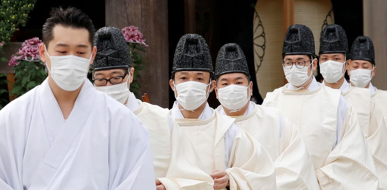 Priests wearing face masks as a precaution against the coronavirus disease enter the main shrine before a celebration marking 100 years since the enshrinement of Emperor Meiji at Meiji Shrine in Tokyo, Japan. Credit: Reuters Photo