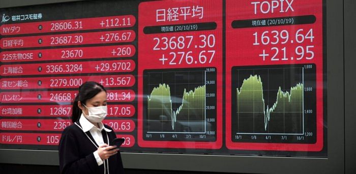 Woman walks past an electronic quotation board displaying share prices on the Tokyo Stock Exchange (C) in Tokyo. Credit: AFP Photo