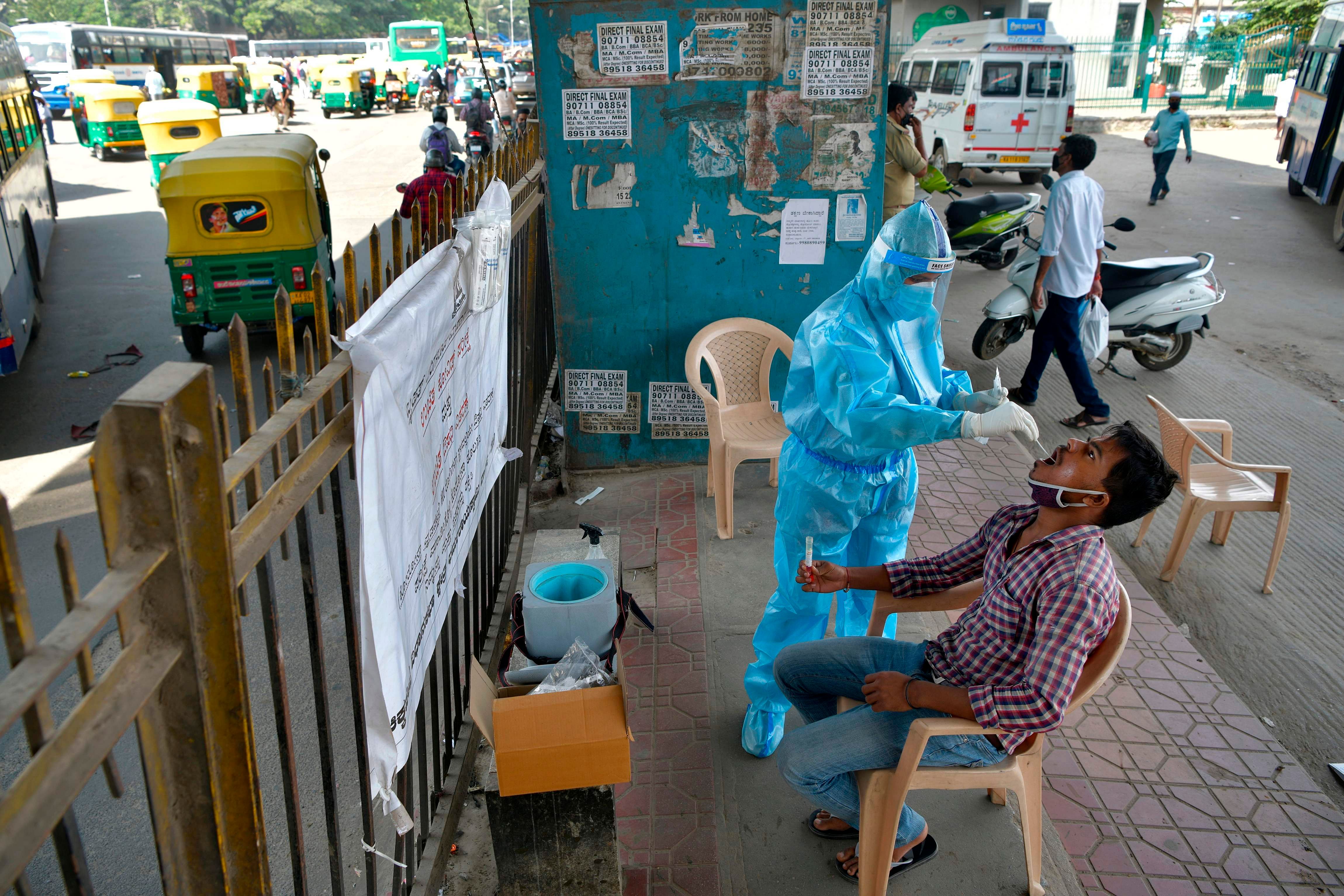 A health worker conducts swab test on a man at a mobile Covid-19 coronavirus testing clinic. Credits: AFP Photo