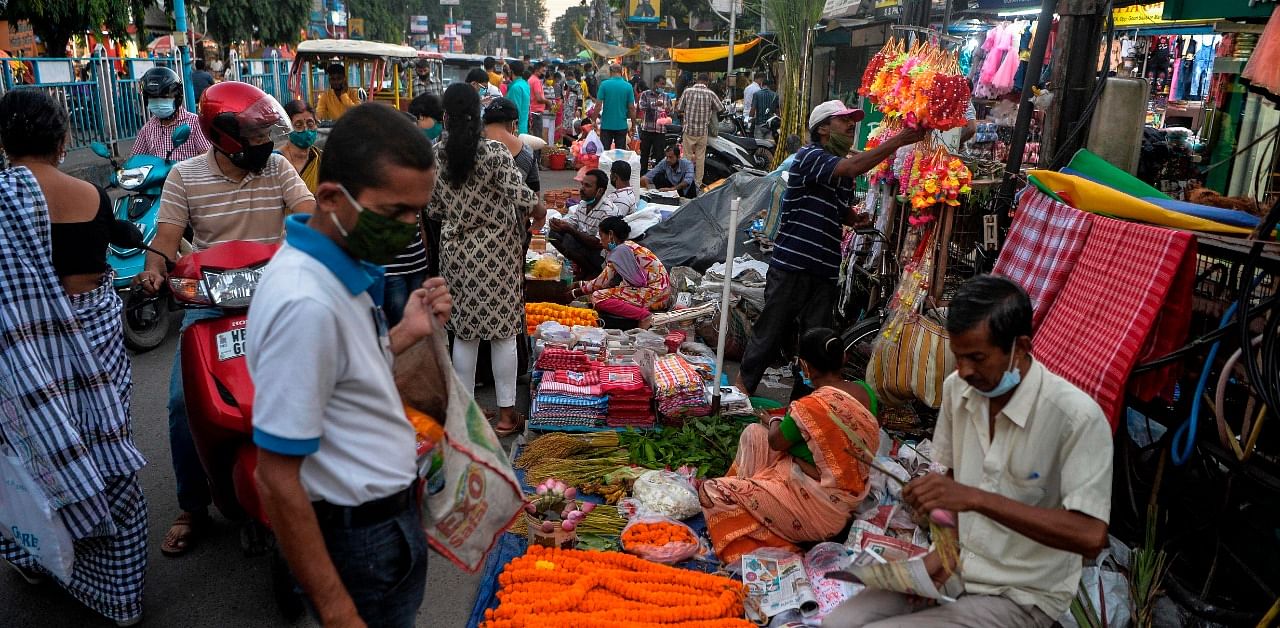 People gather to buy goods in market area along a street in Siliguri on October 29, 2020. Credit: AFP Photo