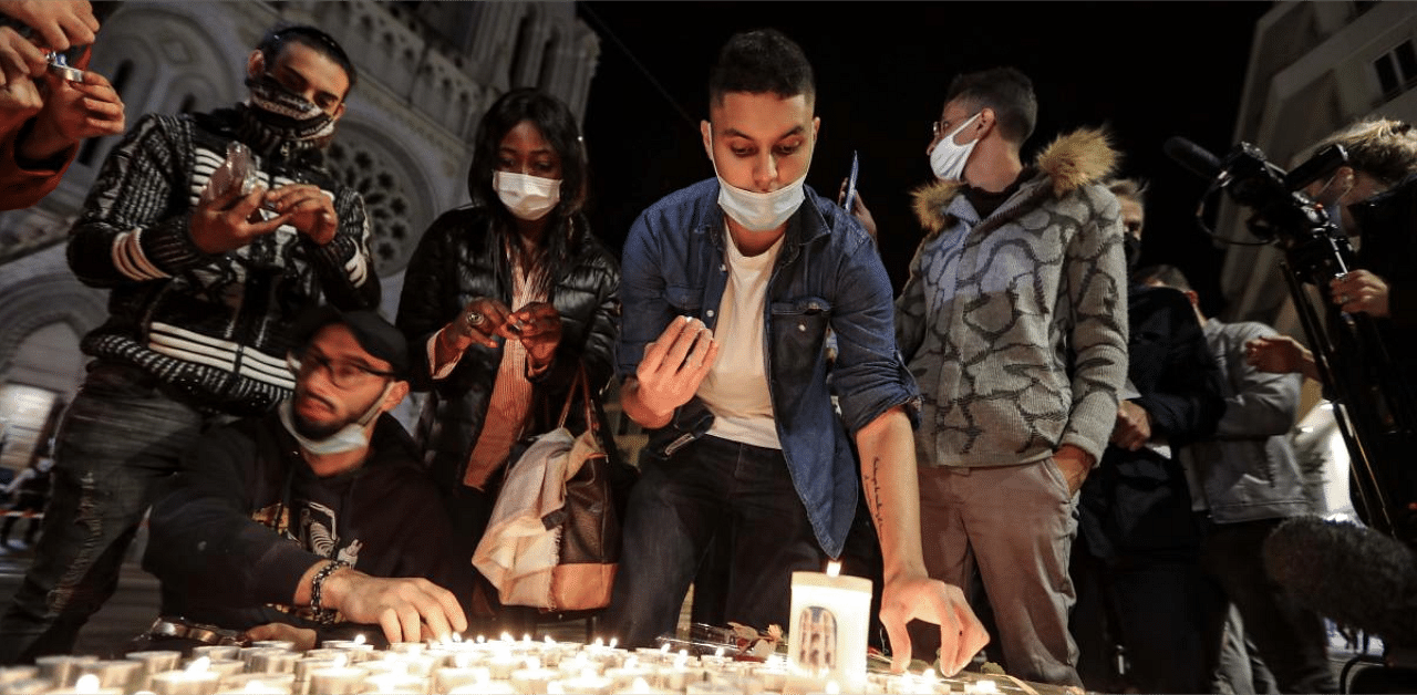 People lights candle outside the Notre-Dame de l'Assomption Basilica in Nice. Credit: AFP