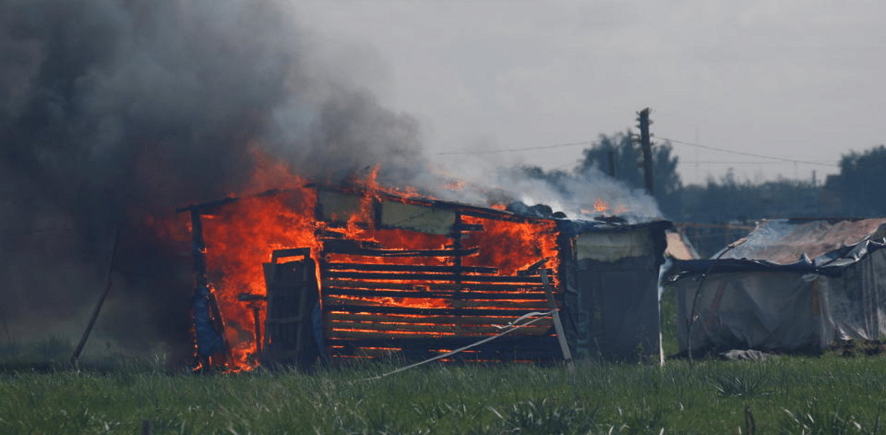 A shack home burns during an eviction in a squatters camp in Guernica, on the outskirts of Buenos Aires, Argentina October 29, 2020. Credit: Reuters Photo