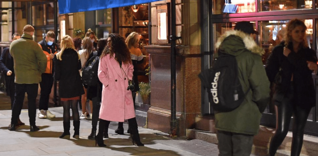 People queue to enter a bar on Peter Street in Manchester city centre, northwest England on October 22, 2020 ahead of new coronavirus restrictions coming into force.  Credit: AFP Photo