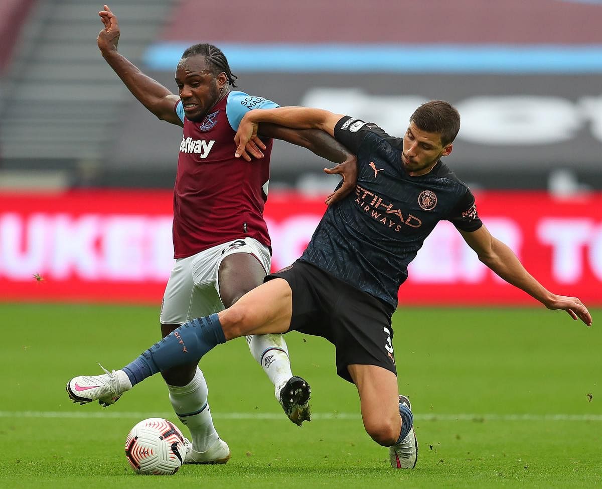 Manchester City's Portuguese defender Ruben Dias (R) vies with West Ham United's English midfielder Michail Antonio. Credit: AFP