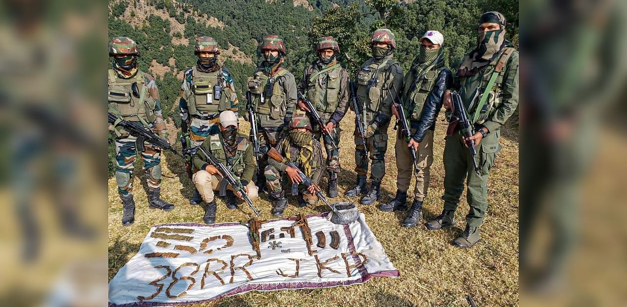 Army personnel display arms and ammunition seized from a militant hideout at Gambhir Mughlan area of Manjakote in Rajouri district. Credit: PTI.